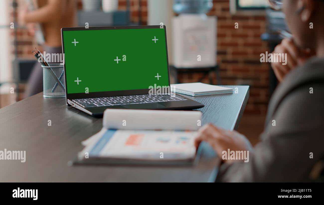 Man using greenscreen on laptop and taking notes at office job ...