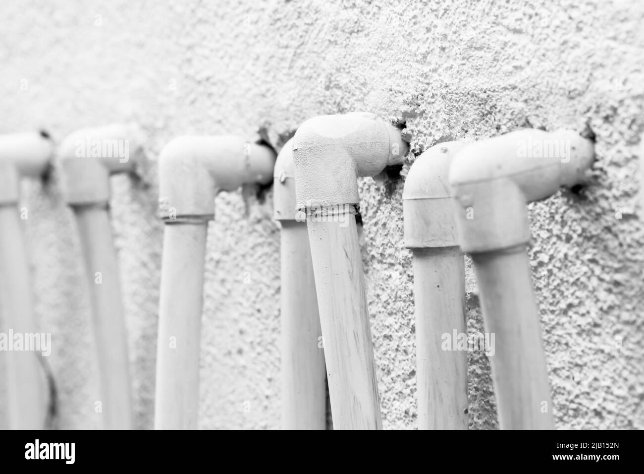 White plastic pipe corners in a row, close up photo with selective focus Stock Photo