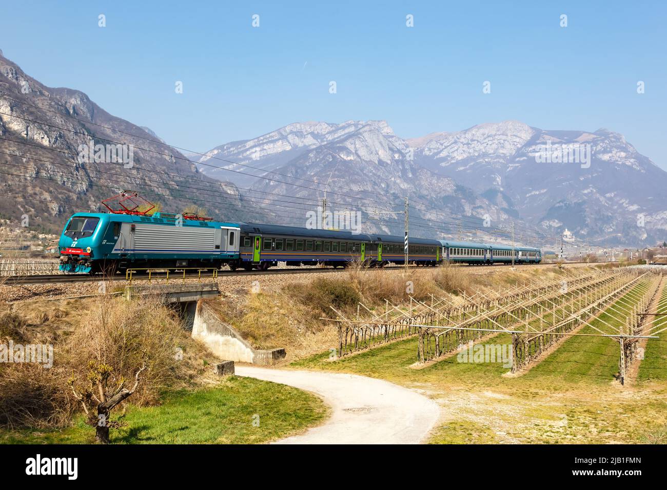 Avio, Italy - March 25, 2022: EuroCity train of Trenitalia on Brenner Railway near Avio, Italy. Stock Photo