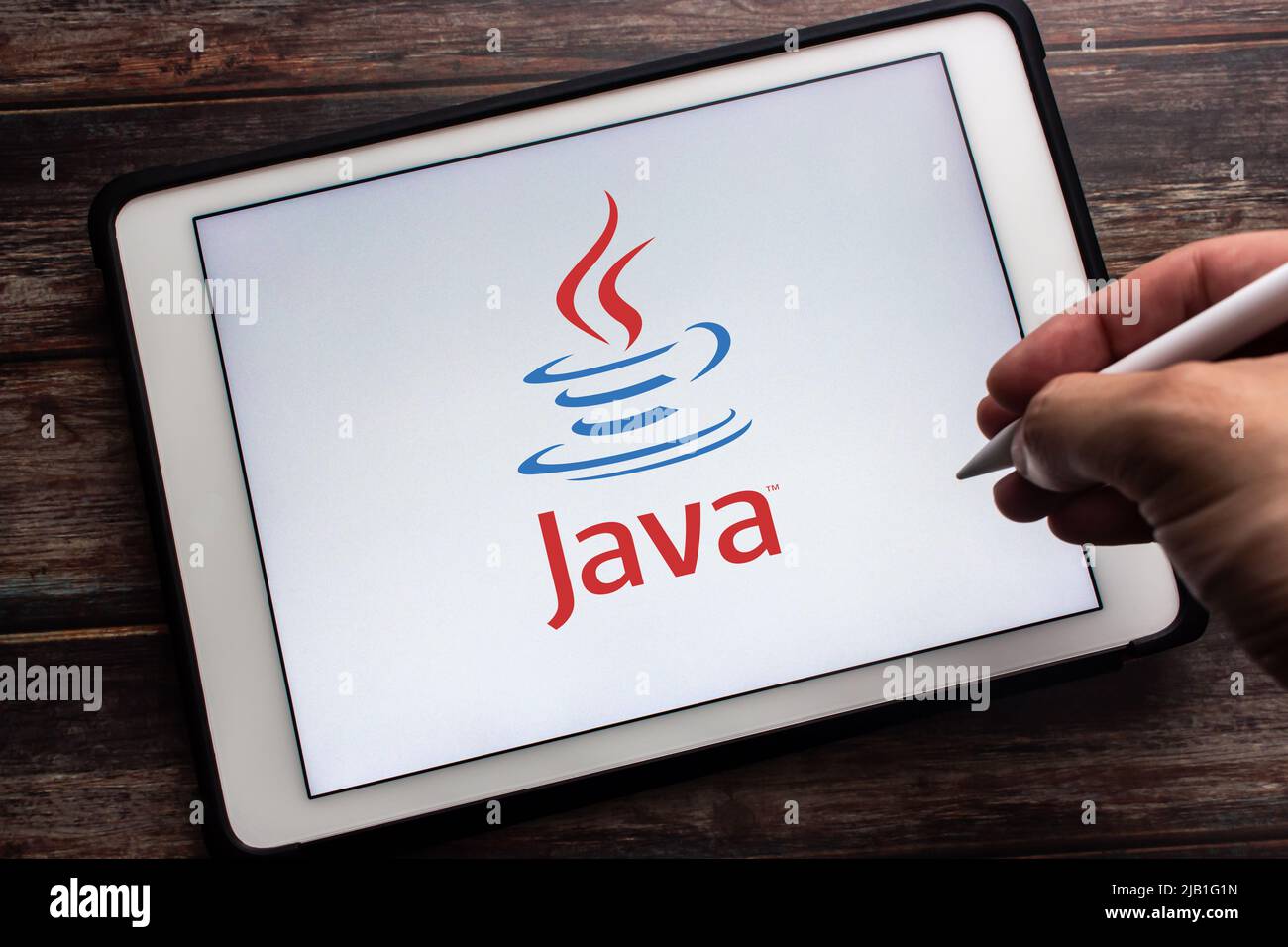 Kumamoto, JAPAN - May 13 2021 : Logo of Java on tablet. Java is the popular class-based, object-oriented programming language. Man holding stylus pen. Stock Photo