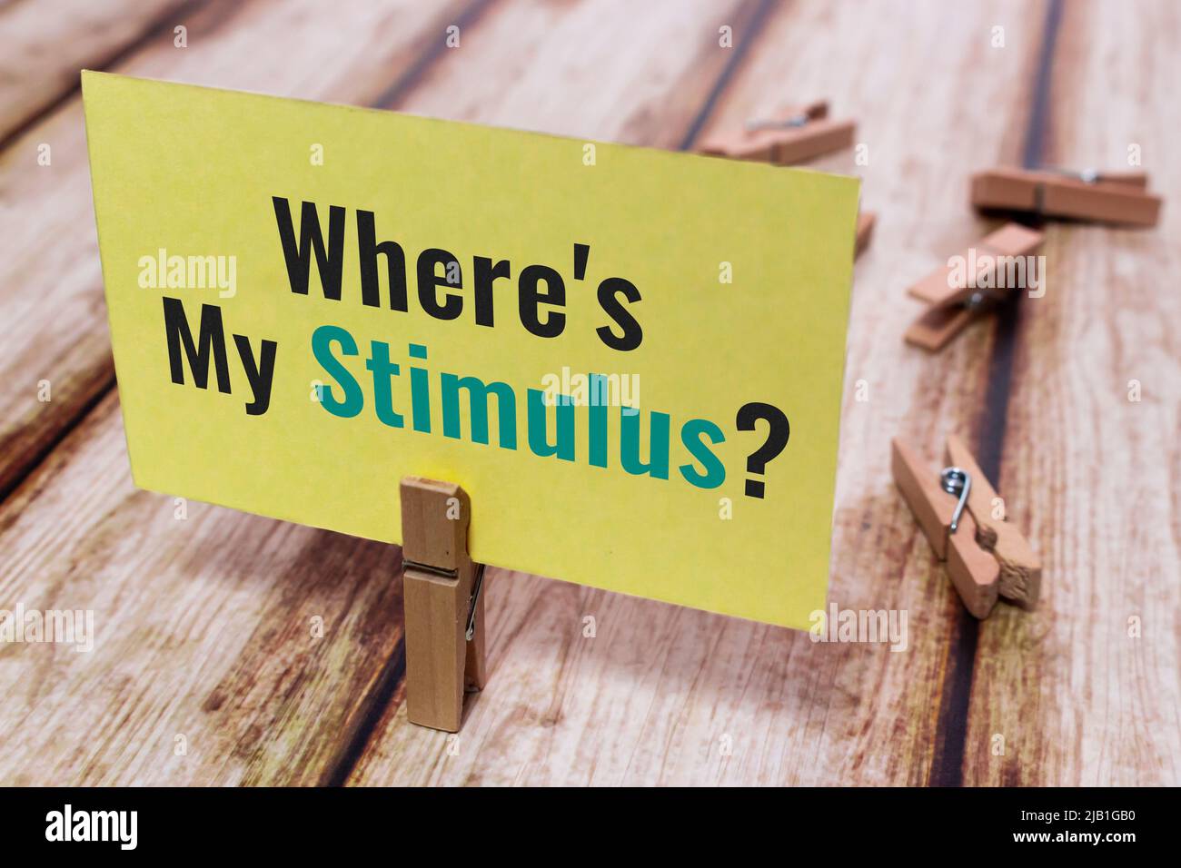 Message card “Where is My Stimulus?” on shabby chic table. Natural wooden pinch holding paper note. Economic stimulus by government program concept Stock Photo