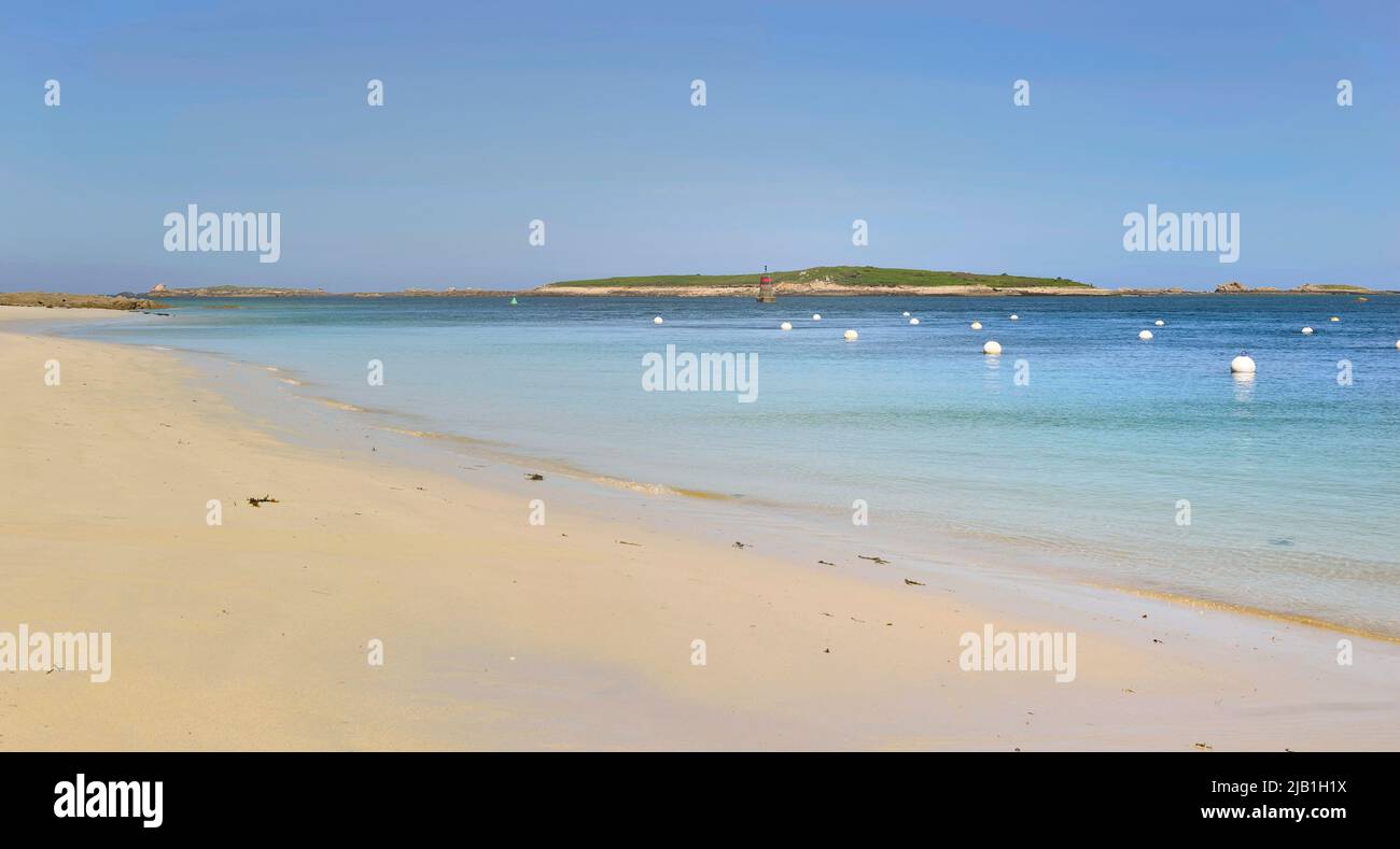 view of a beach with fine white sand and clear blue water in Brittany - France Stock Photo