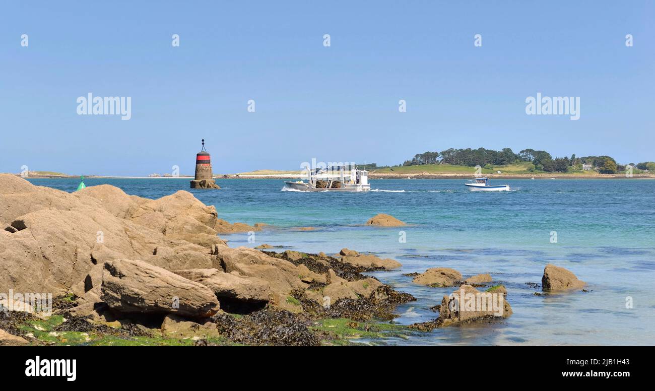 rocky beach  view with boats and beacon  background in aber Benoit, Brittany- France Stock Photo