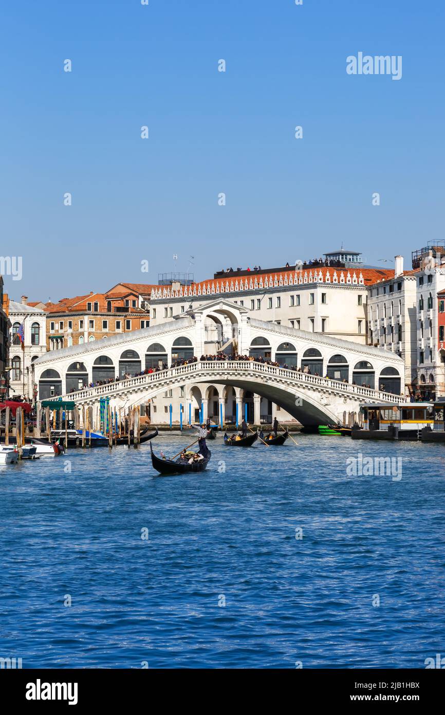 Venice Rialto bridge over Canal Grande with gondola travel traveling holidays vacation city town portrait format in Italy Stock Photo