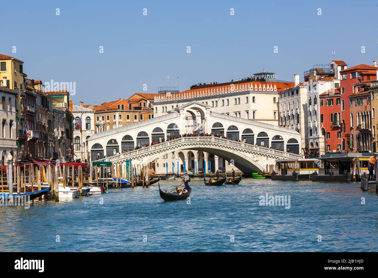 Venice Rialto bridge over Canal Grande with gondola travel traveling holidays vacation city town in Italy Stock Photo