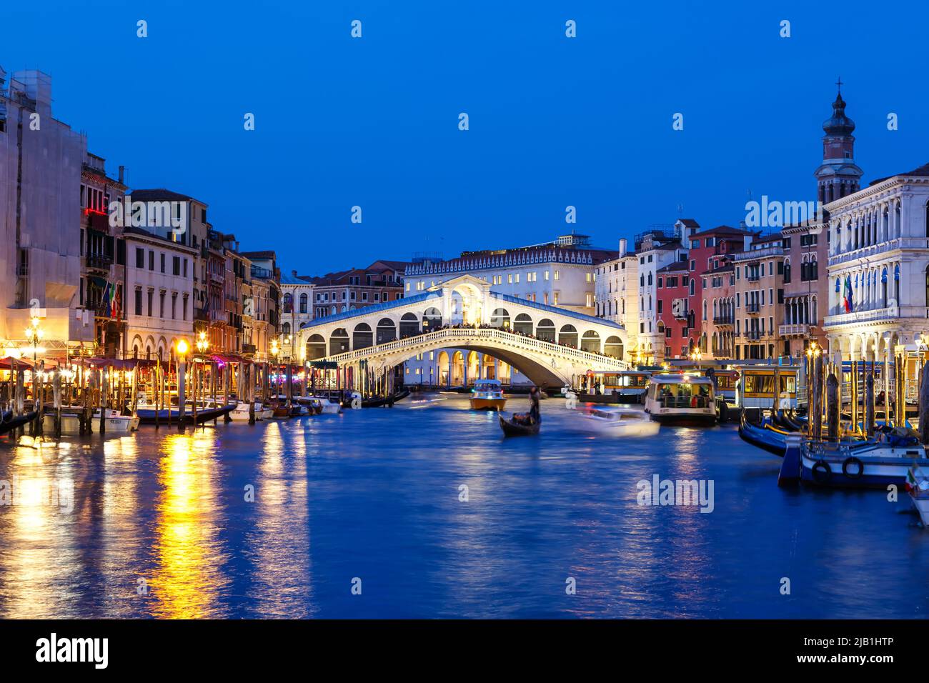 Venice Rialto bridge over Canal Grande with gondola travel traveling holidays vacation city town in Italy Stock Photo