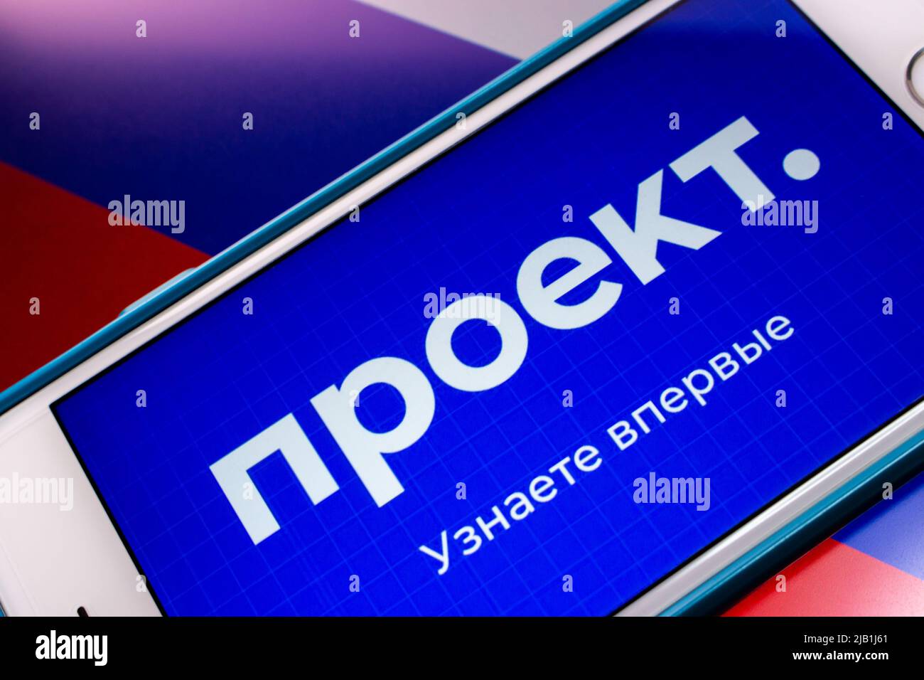Kumamoto, JAPAN - Jul 19 2021 : Logo of Proekt Media, an Russian media specializing in investigative journalism, on iPhone on Russian Flag Stock Photo