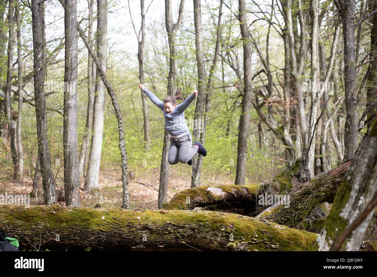 Little girl having fun, jumping in the forest. The concept of outdoor ...