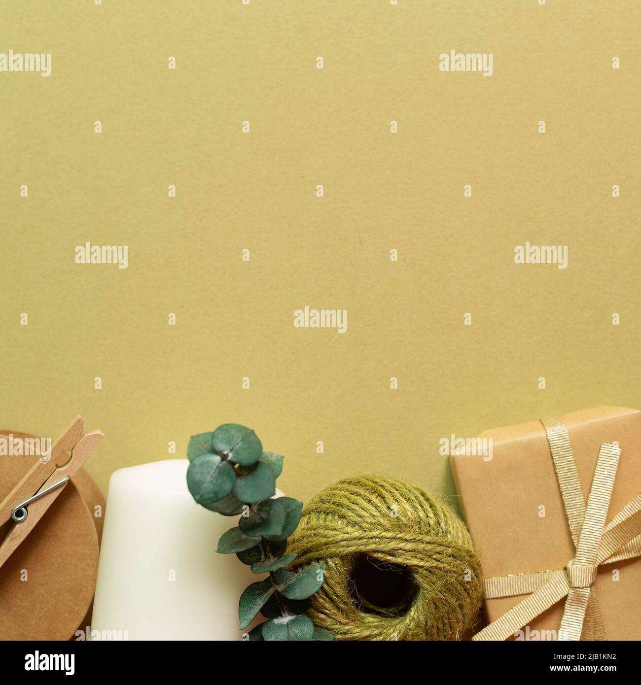 Brown gift box, string reel, candle on khaki green background. flat lay ...