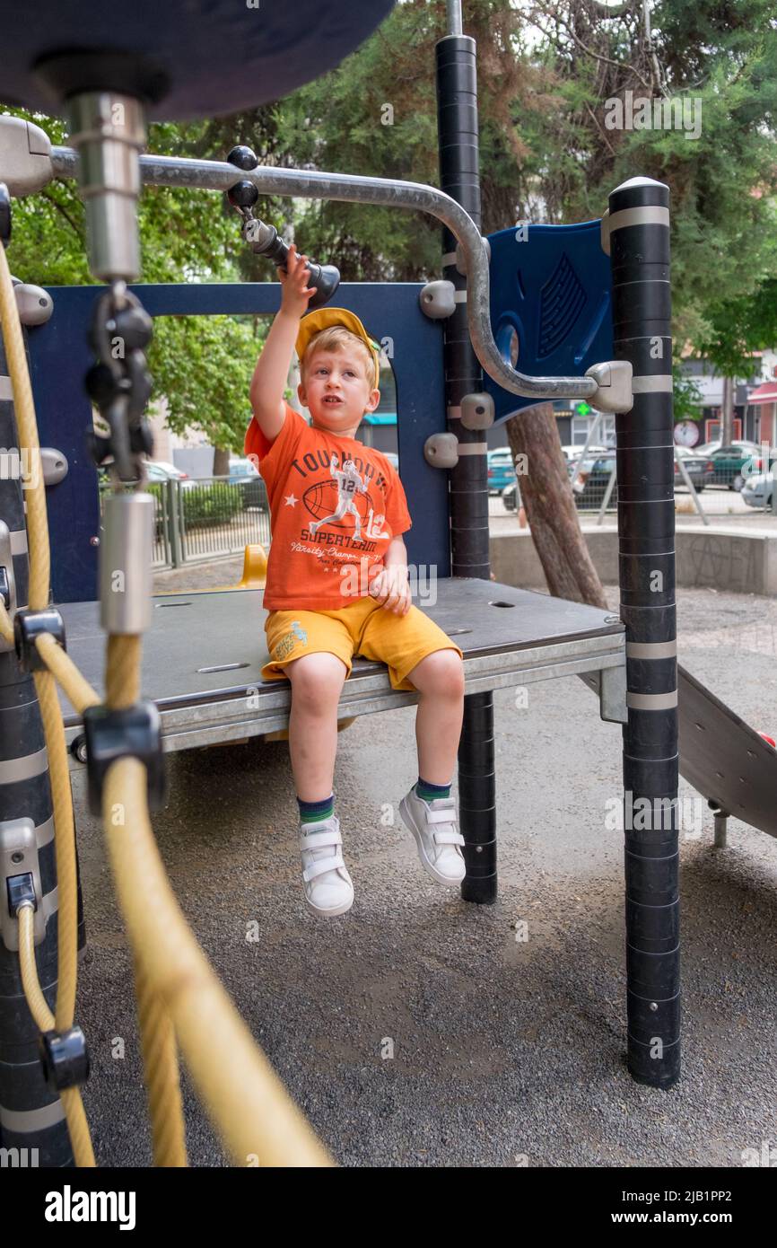 Cute little boy playing in the playground Stock Photo - Alamy