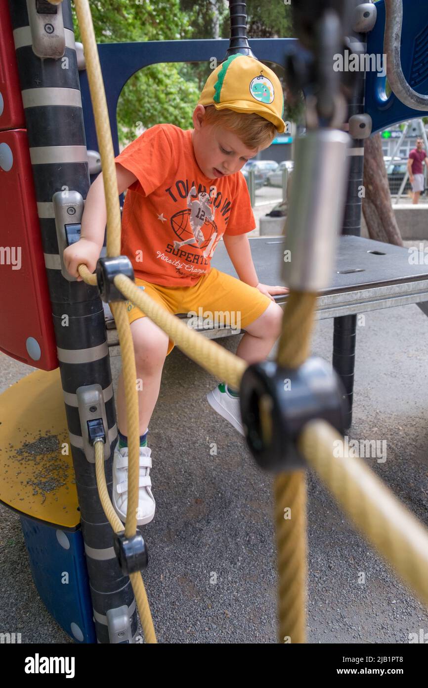 Cute little boy playing in the playground Stock Photo - Alamy
