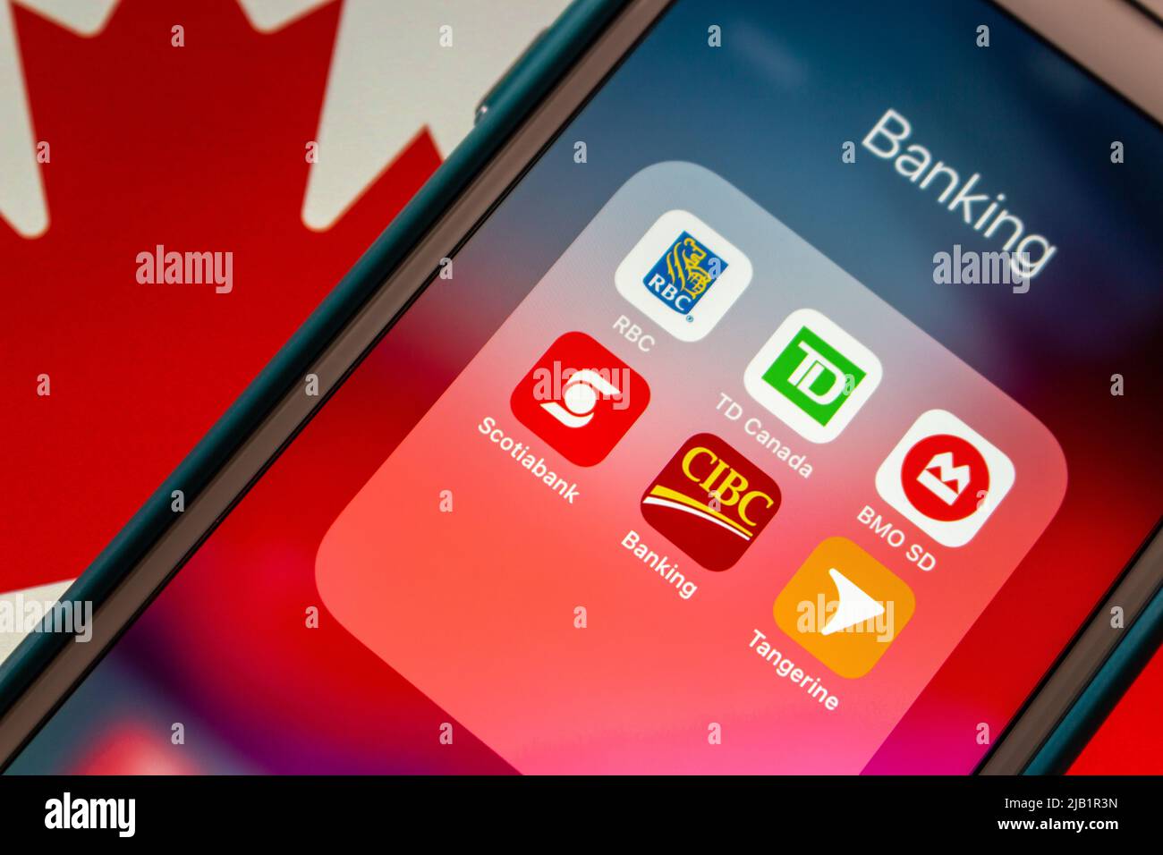 Royal Bank of Canada, TD Canada Trust, Bank of Montreal, Scotiabank, Canadian Imperial Bank of Commerce, Tangerine on iPhone on Canadian flag Stock Photo