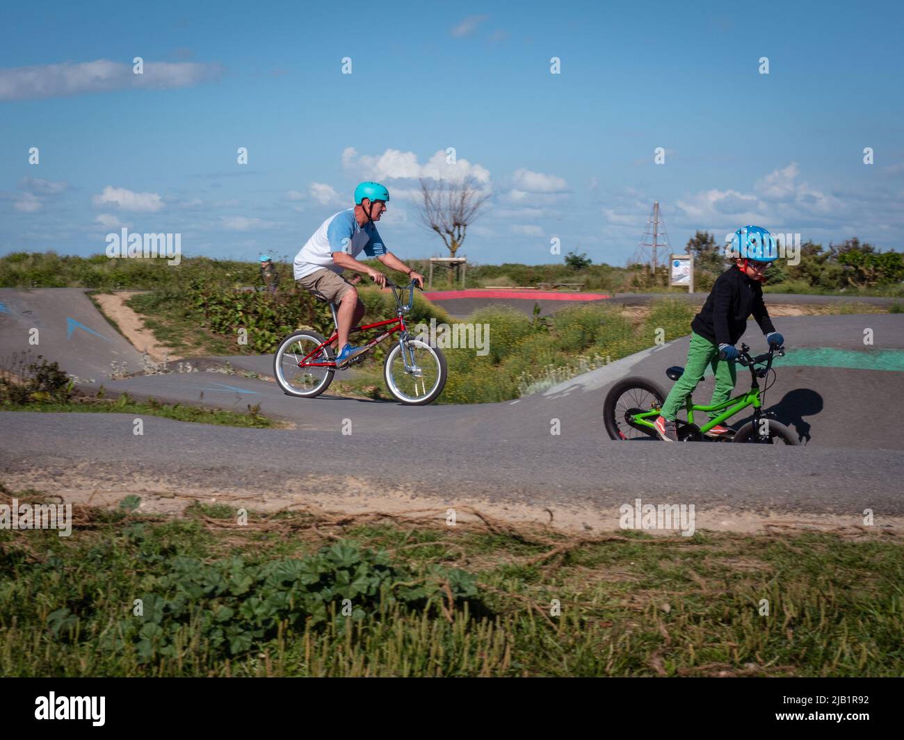 Merville, France, May 2022. Man with a helmet riding a BMX bike in the skate park. Sunny day, relaxation, sports lifestyle Stock Photo