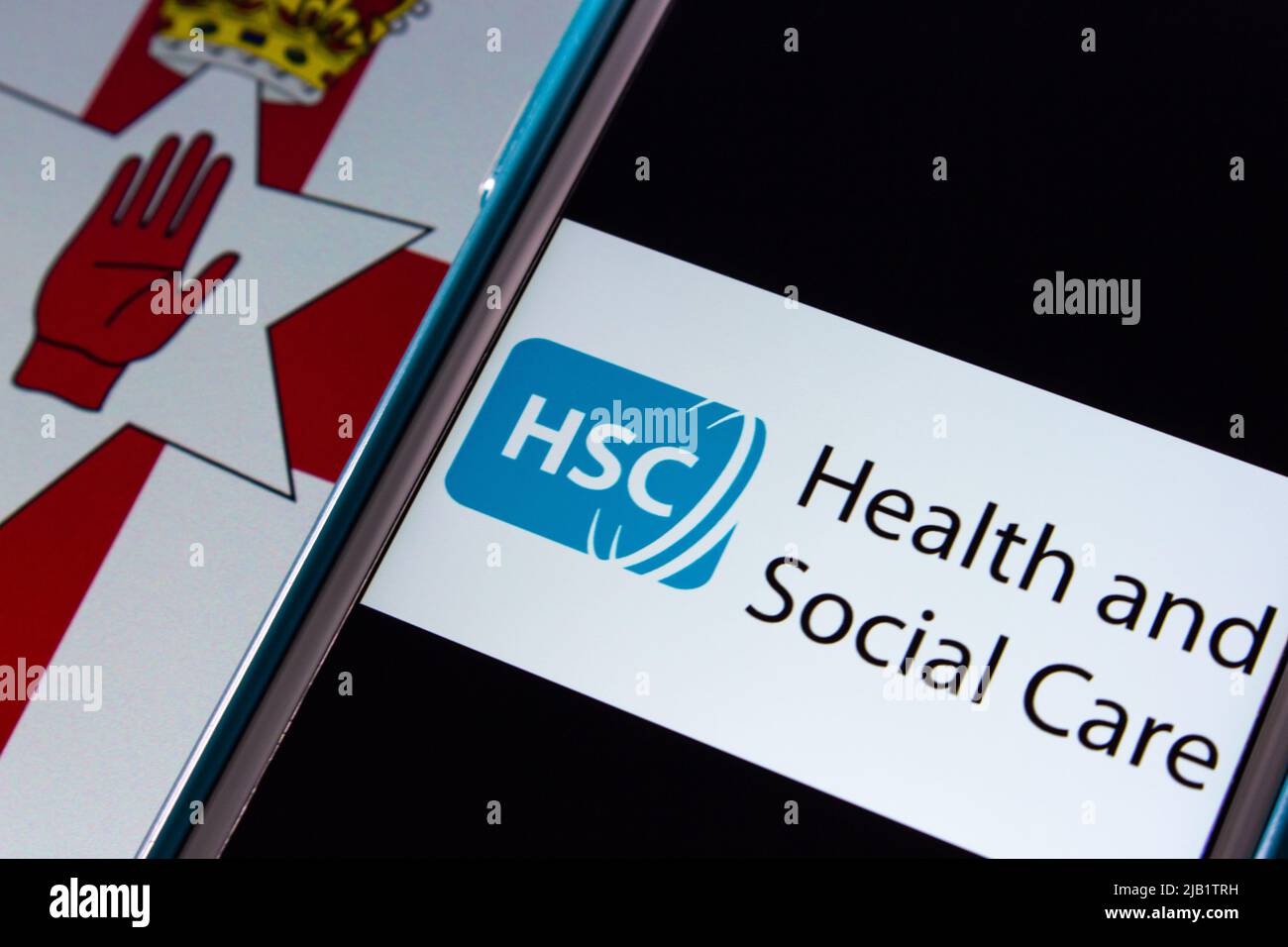 Kumamoto, JAPAN - Sep 6 2021 : HSC Health & Social Care, healthcare system in Northern Ireland (separately to NHS), on iPhone on Northern Ireland flag Stock Photo