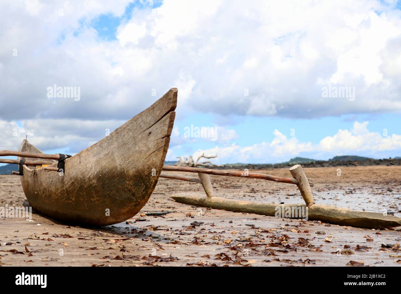 Ein Fischerboot wartet auf Restaurierung am Strand. Verlassen steht es einsam am Meeresboden des indischen Ozean. Stock Photo