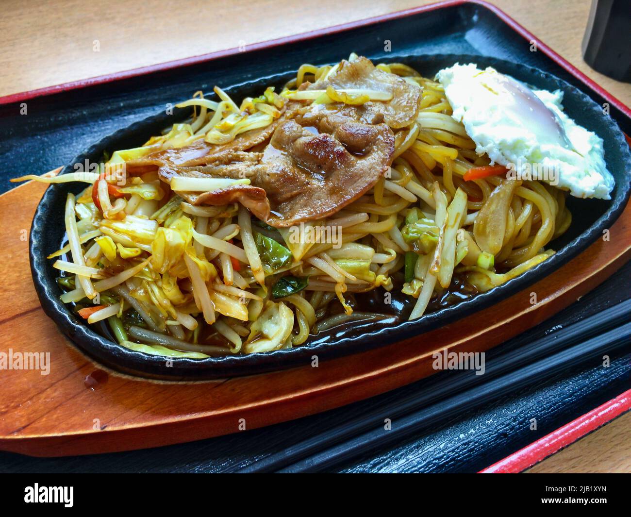 Japanese fried noodle Yakisoba with medamayaki (fried egg) plate. Yakisoba is a frying ramen-style wheat noodles with bite-sized porks & vegetables Stock Photo