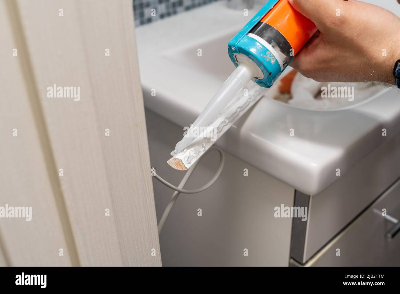 Plumber caulking bath tube with silicone glue using cartridge Stock