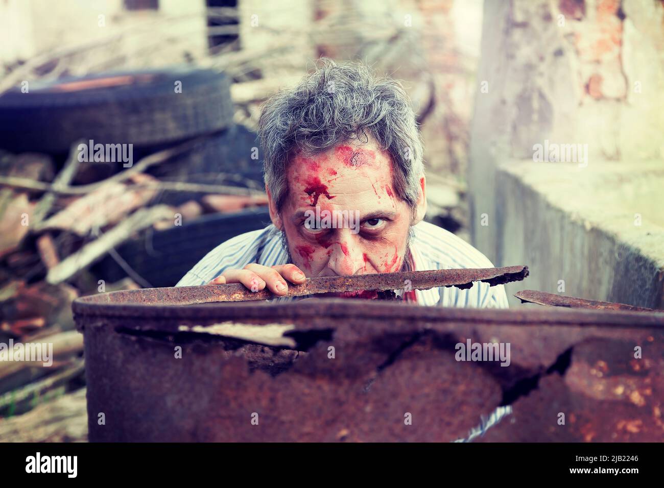 scary bloody zombie man in the ruins of an old house Stock Photo