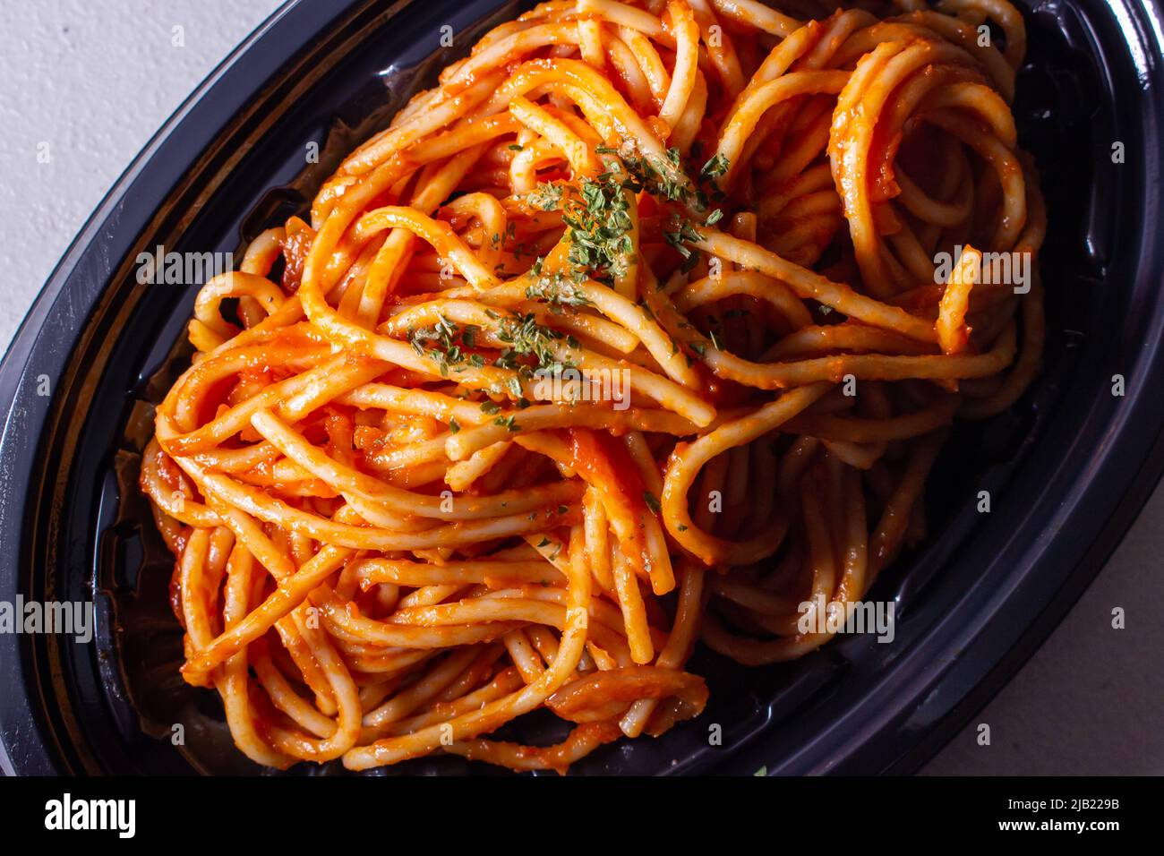 Takeout Japanese Naporitan Spaghetti in a food tray. Naporitan (or Napolitan) is a Japanese pasta dish. It consists of spaghetti, tomato ketchup Stock Photo