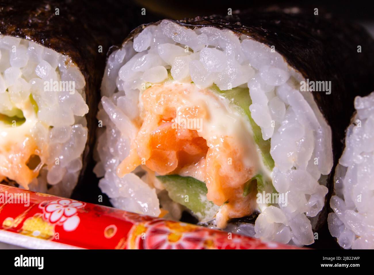 The closeup of the takeout salmon maki zushi (salmon sushi rolls) packed in the plastic food container. Stock Photo