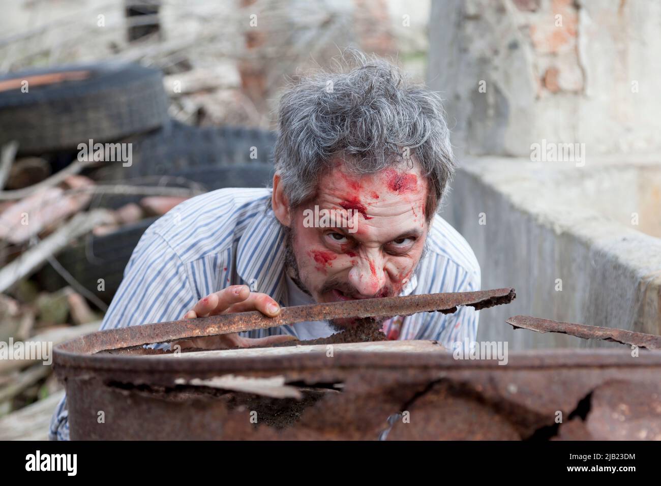 scary bloody zombie man in the ruins of an old house Stock Photo