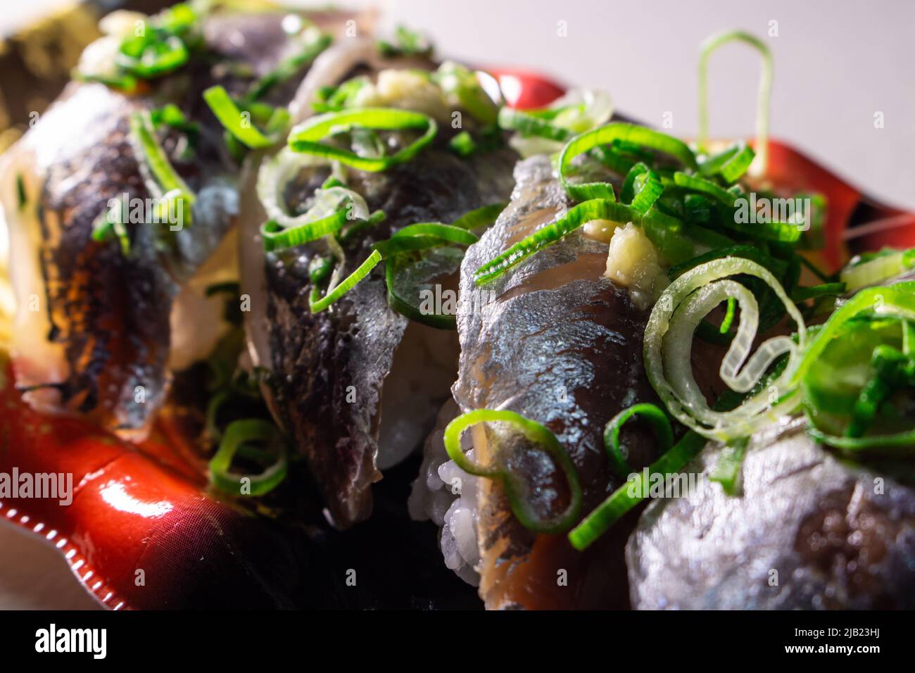 Horse Mackerel Sushi (Aji Sushi) with green onions & grated ginger packed in a food tray. Aji is