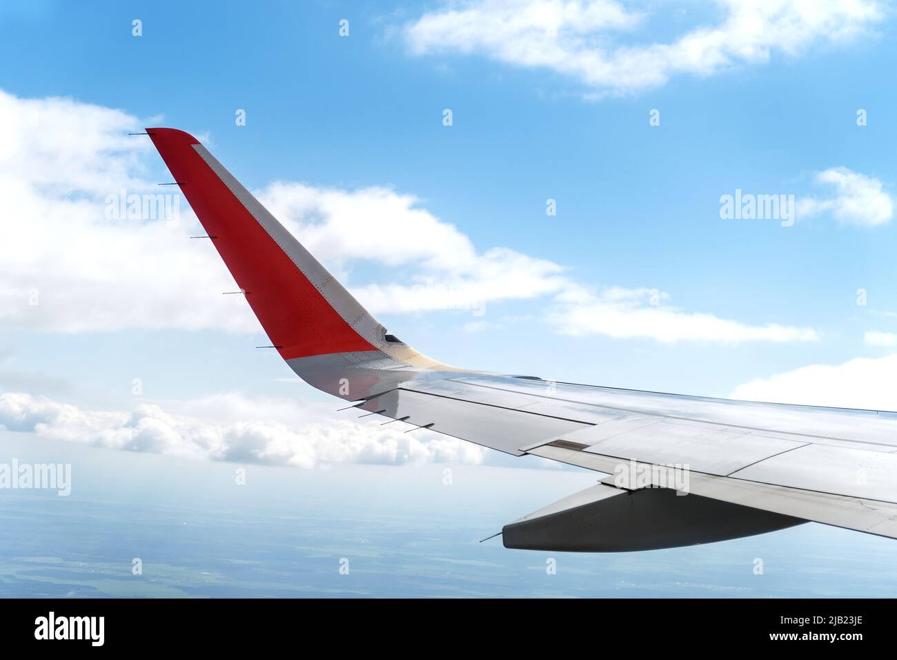 View from the window of the aircraft on the wing of the aircraft and the sky clouds. Selective focus. Vacation, travel concept. Stock Photo