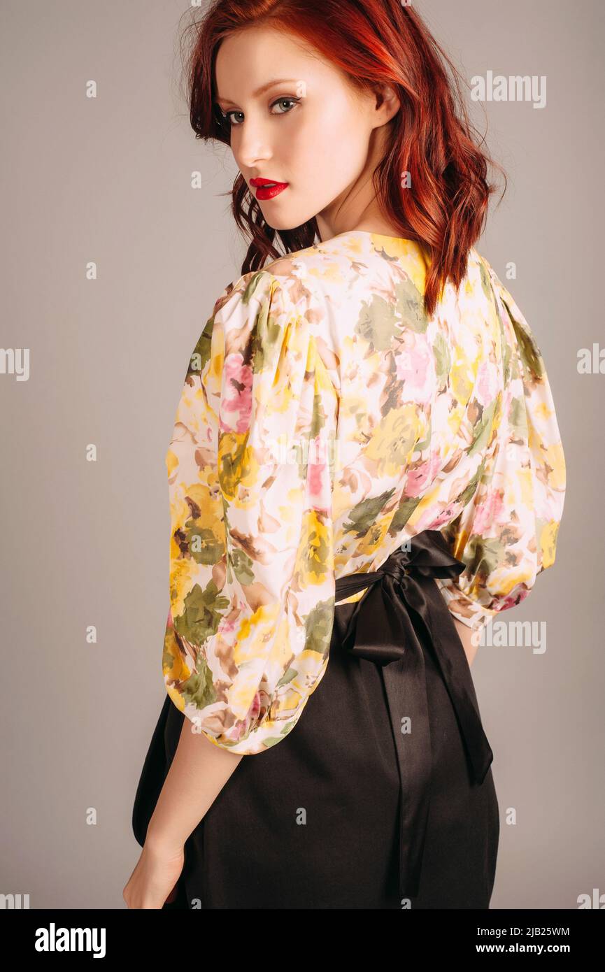 Female fashion. Redhead lady in elegant mini evening dress with long yellow balloon sleeves and black skirt on grey studio background. Young woman wit Stock Photo - Alamy Female fashion. Redhead lady in elegant mini evening dress with long yellow balloon sleeves and black skirt on grey studio background. Young woman wit Stock Photo - Alamy