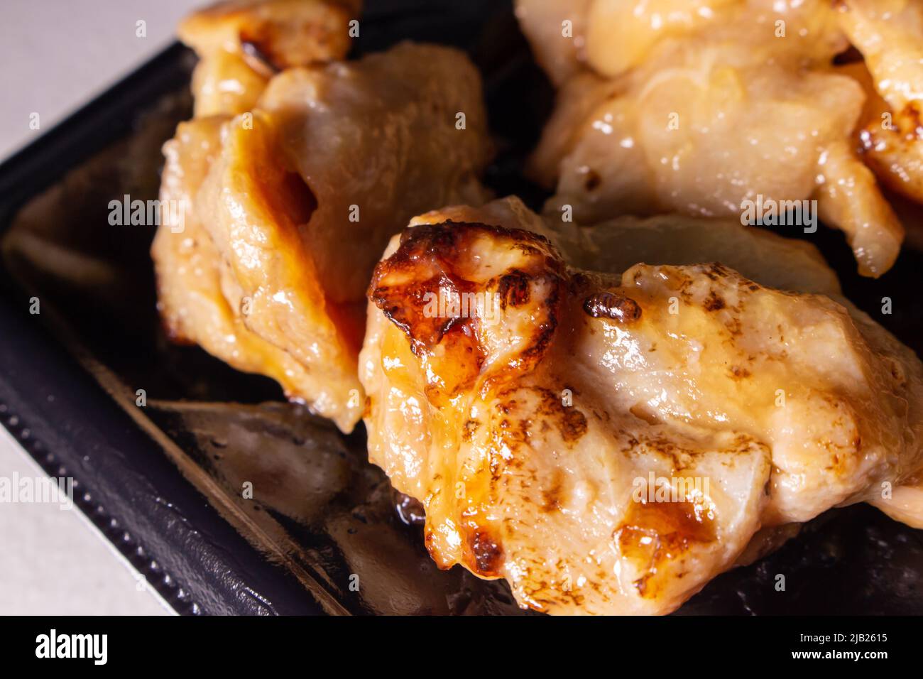 A takeout Japanese Teriyaki chicken in a container. Teriyaki is a cooking technique used in which foods are grilled with a soy sauce, mirin, and sugar Stock Photo