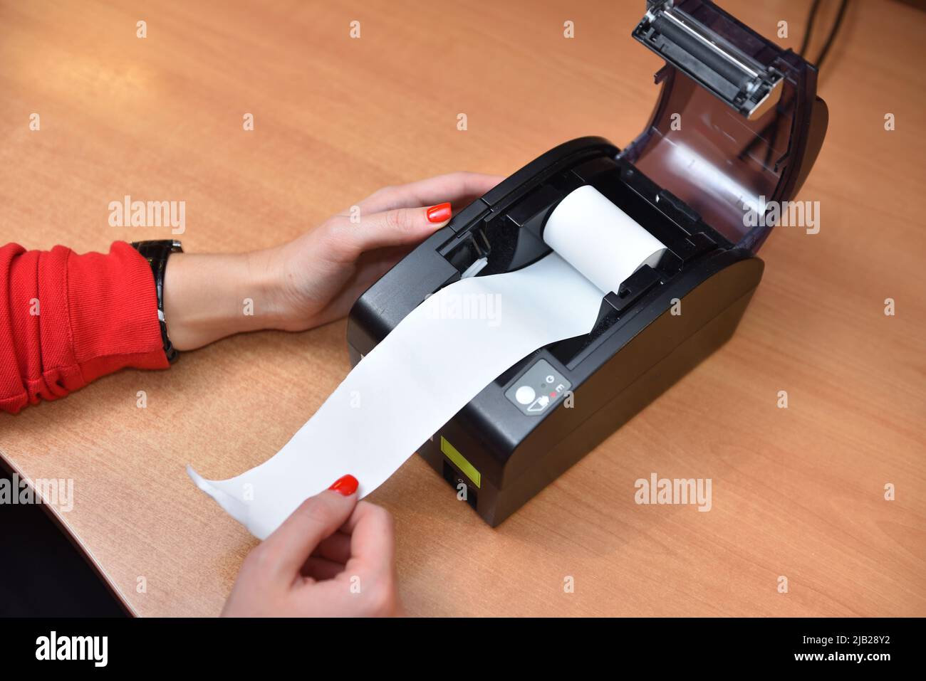 Cashier changes the paper in the cash register Stock Photo Alamy