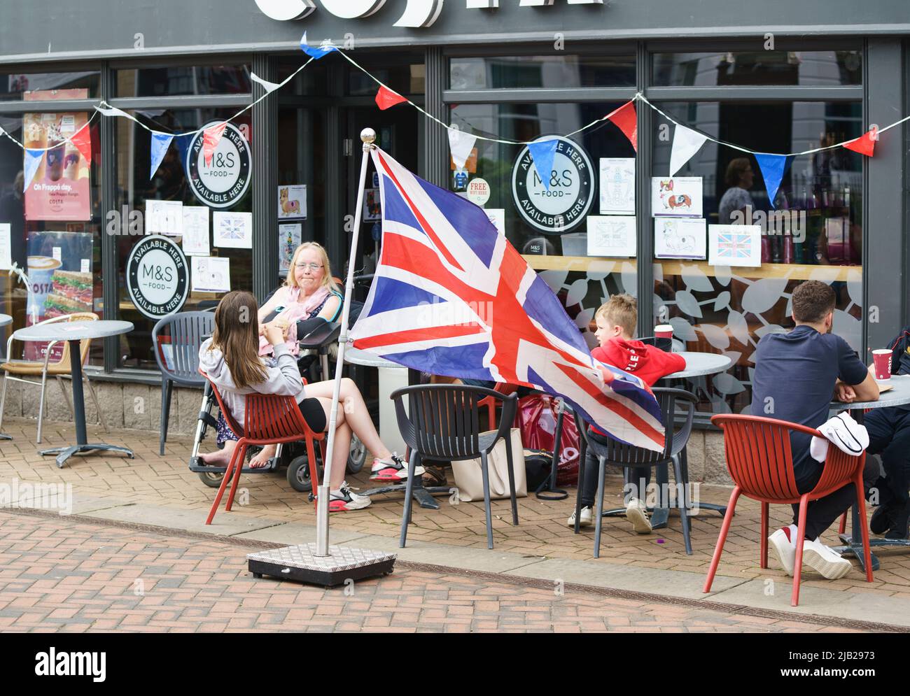 Bicester, Oxfordshire, UK. 2nd June 2022. The UK nations begin a 4 day long weekend to celebrate HM The Queen’s Platinum Jubilee. PICTURED: Bicester town centre celebrates. Cost Coffee. Credit: Bridget Catterall/Alamy Live News. Stock Photo