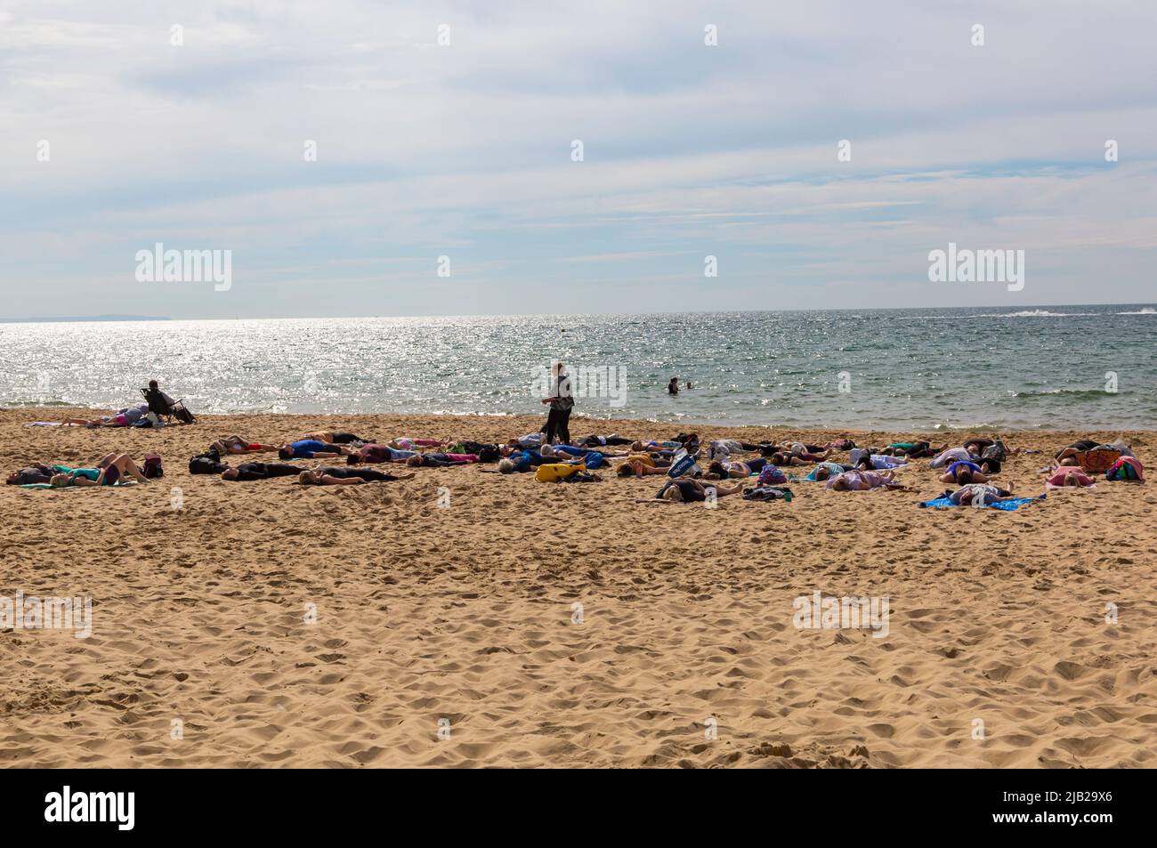 Bournemouth, Dorset UK. 2nd June 2022. UK weather: lovely warm and sunny as crowds flock to Bournemouth beaches to enjoy the sunshine at the seaside for the start of the long weekend to celebrate the Queens Platinum Jubilee. Beach yoga and relaxation. Credit: Carolyn Jenkins/Alamy Live News Stock Photo