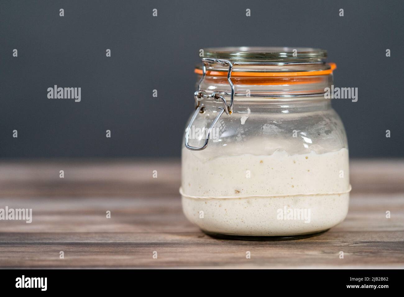 Feeding sourdough starter in a glass mason jar for baking artisan bread