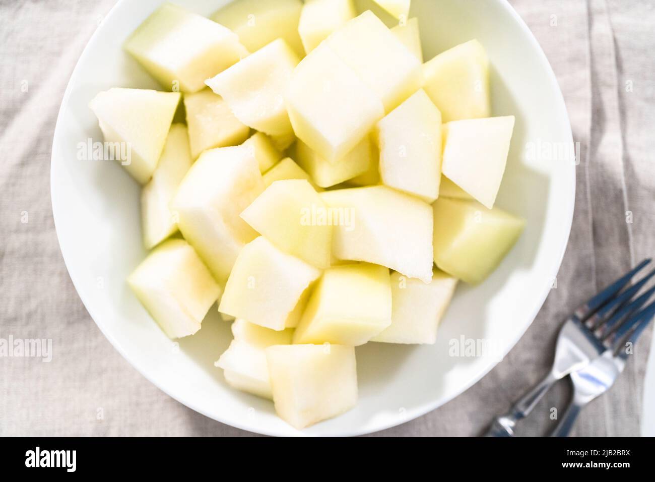 Sliced golden dewlicious melon in a white bowl Stock Photo Alamy