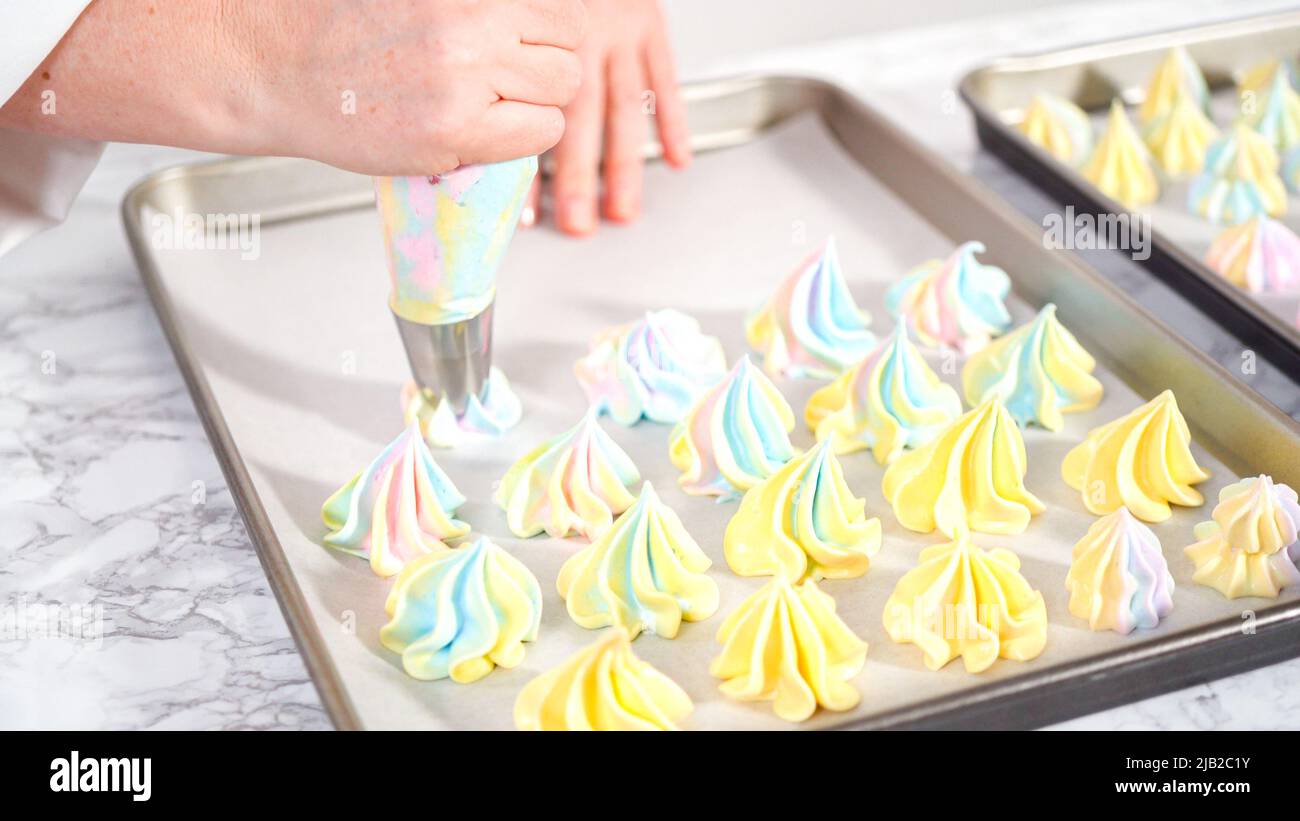 Step by step. Piping unicorn meringue cookies to the baking sheet lined