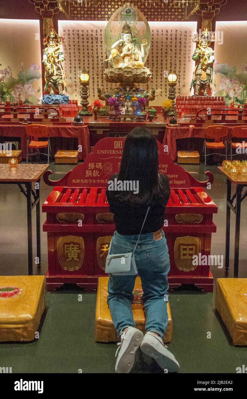 Woman worshipping at the Buddha Tooth Relic Temple, South Bridge Road, Chinatown, Singapore Stock Photo