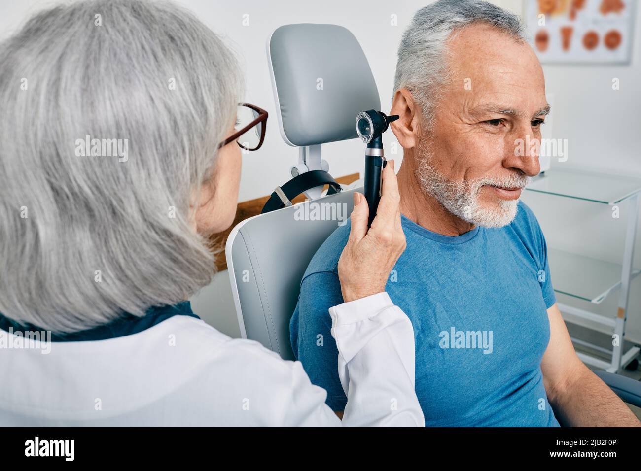 Senior man during ear test with audiologist at audiology. Diagnosis of ...