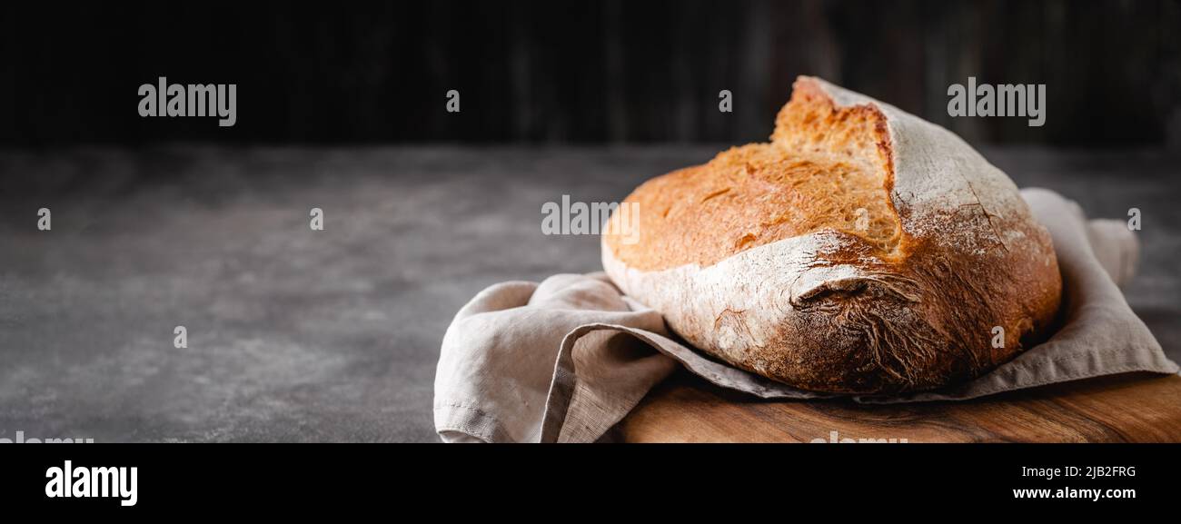 Sourdough freshly baked bread with a crispy crust on a linen napkin. Stock Photo