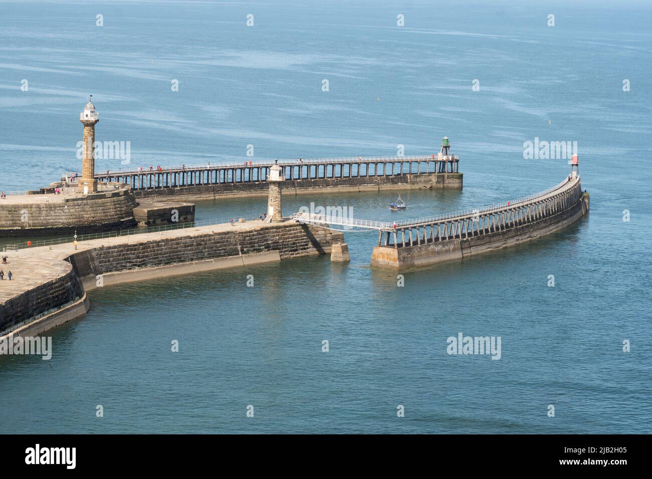 The piers and lighthouses at the entrance to Whitby harbour in Yorkshire, England, UK Stock Photo