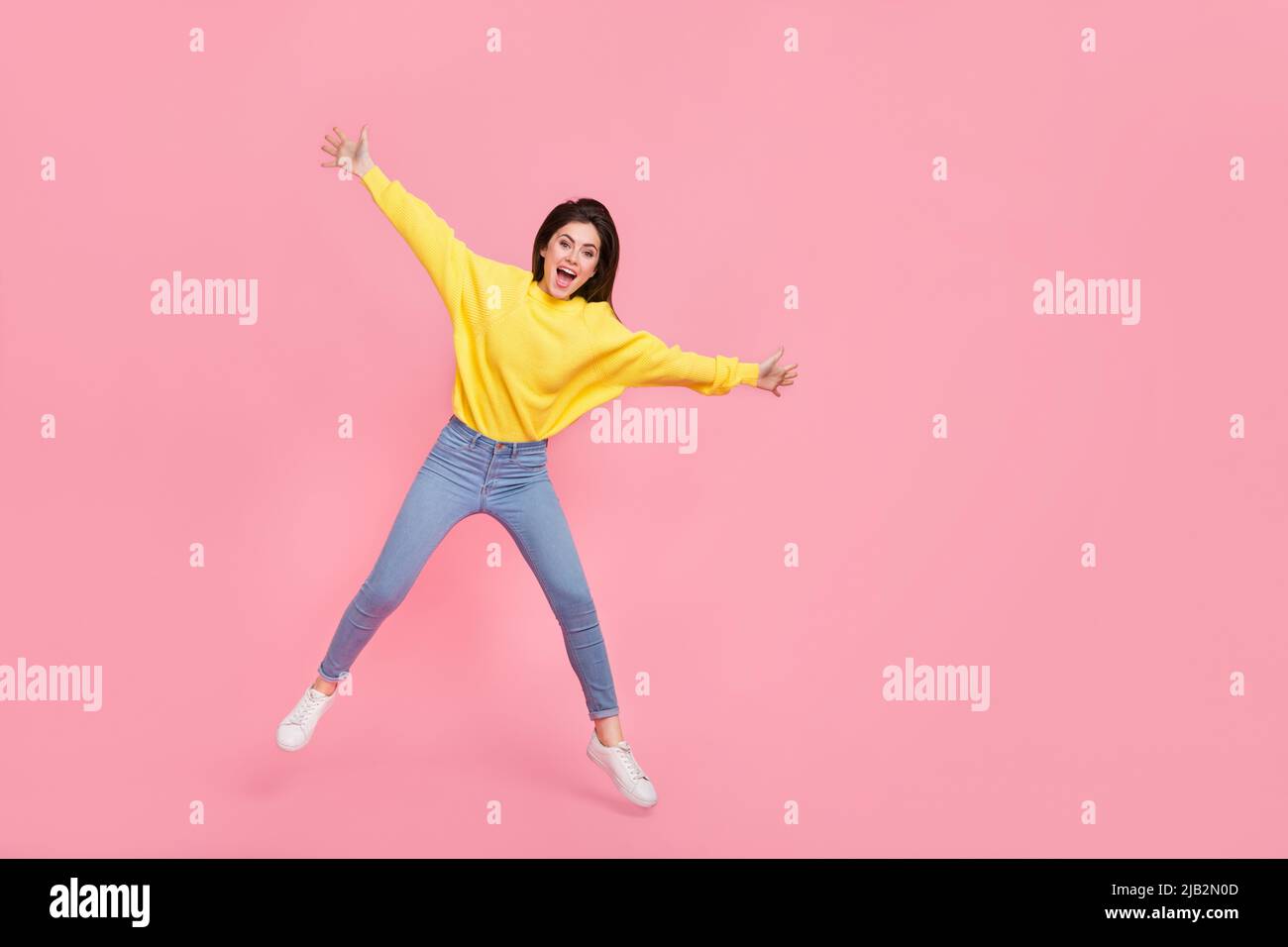 Full body photo of young cheerful woman have fun jumper fly wear casual outfit isolated over pink color background Stock Photo