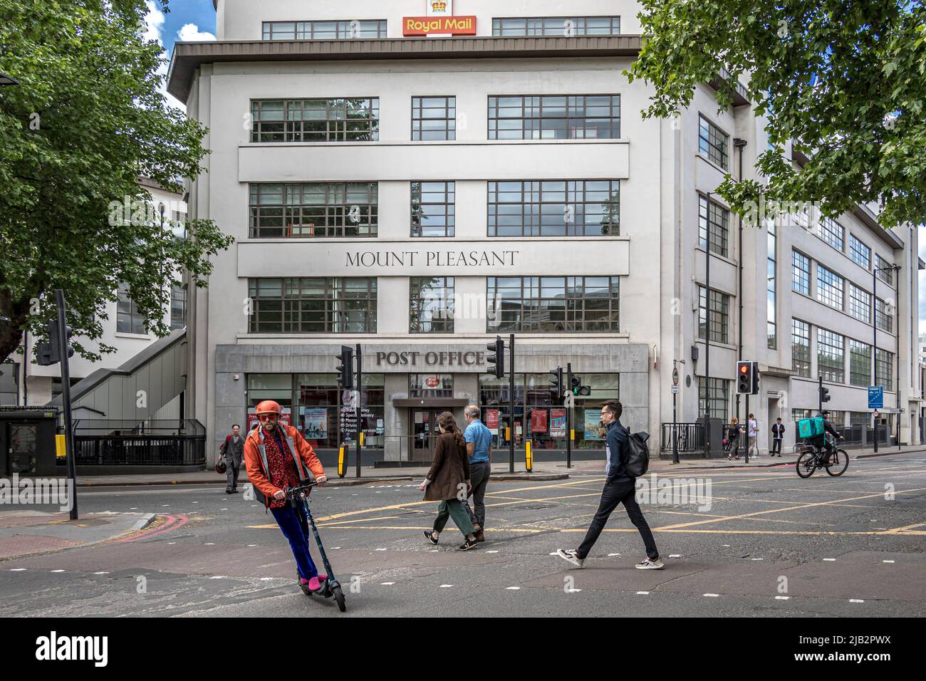 A man on an electric scooter passes near Mount Pleasant sorting offices, Royal Mail's central mail centre for London , Clerkenwell EC1 ,UK Stock Photo