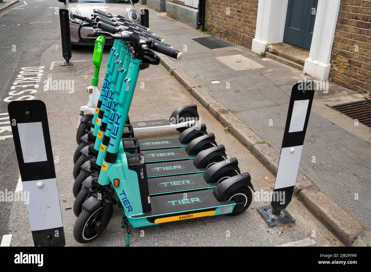 London, UK- May 3, 2022: Tier rental scooters lined up on a street in London Stock Photo