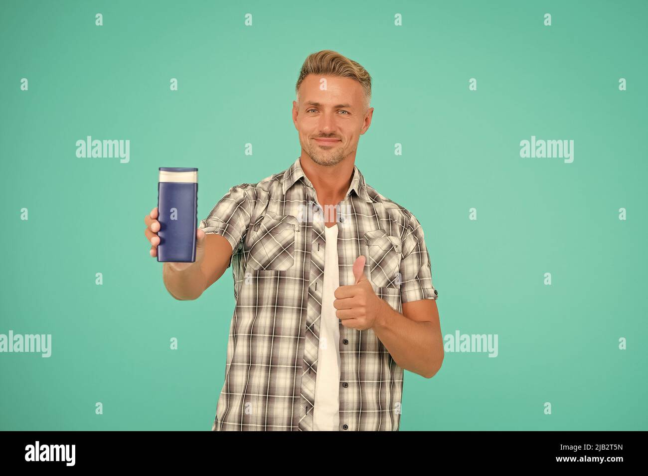 Shower head to toe in joy. Happy man give thumbs up to shower gel bottle.  Approval hand gesture Stock Photo - Alamy