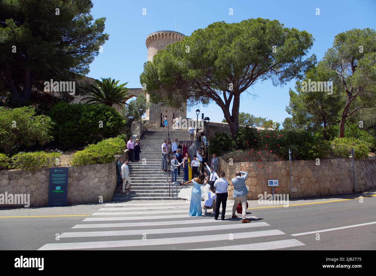 Spain, Balearic Islands, Majorca, Palma de Mallorca, Castle Bellver with wedding party taking photos on the steps. Stock Photo