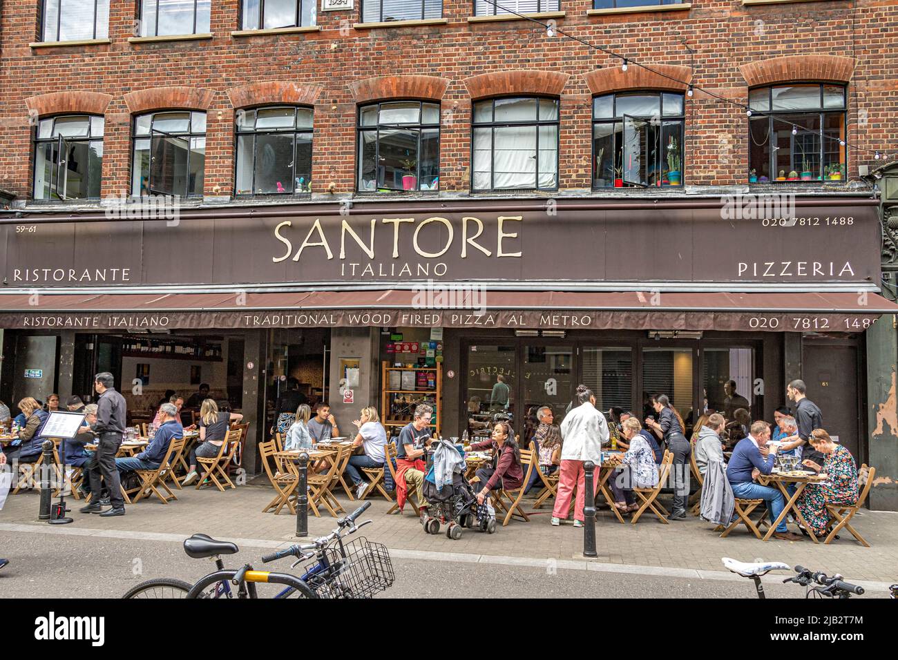 People sitting outside at tables enjoying Italian food at Santore an Italian restaurant & pizzeria on Exmouth Market, Clerkenwell ,London EC1 Stock Photo