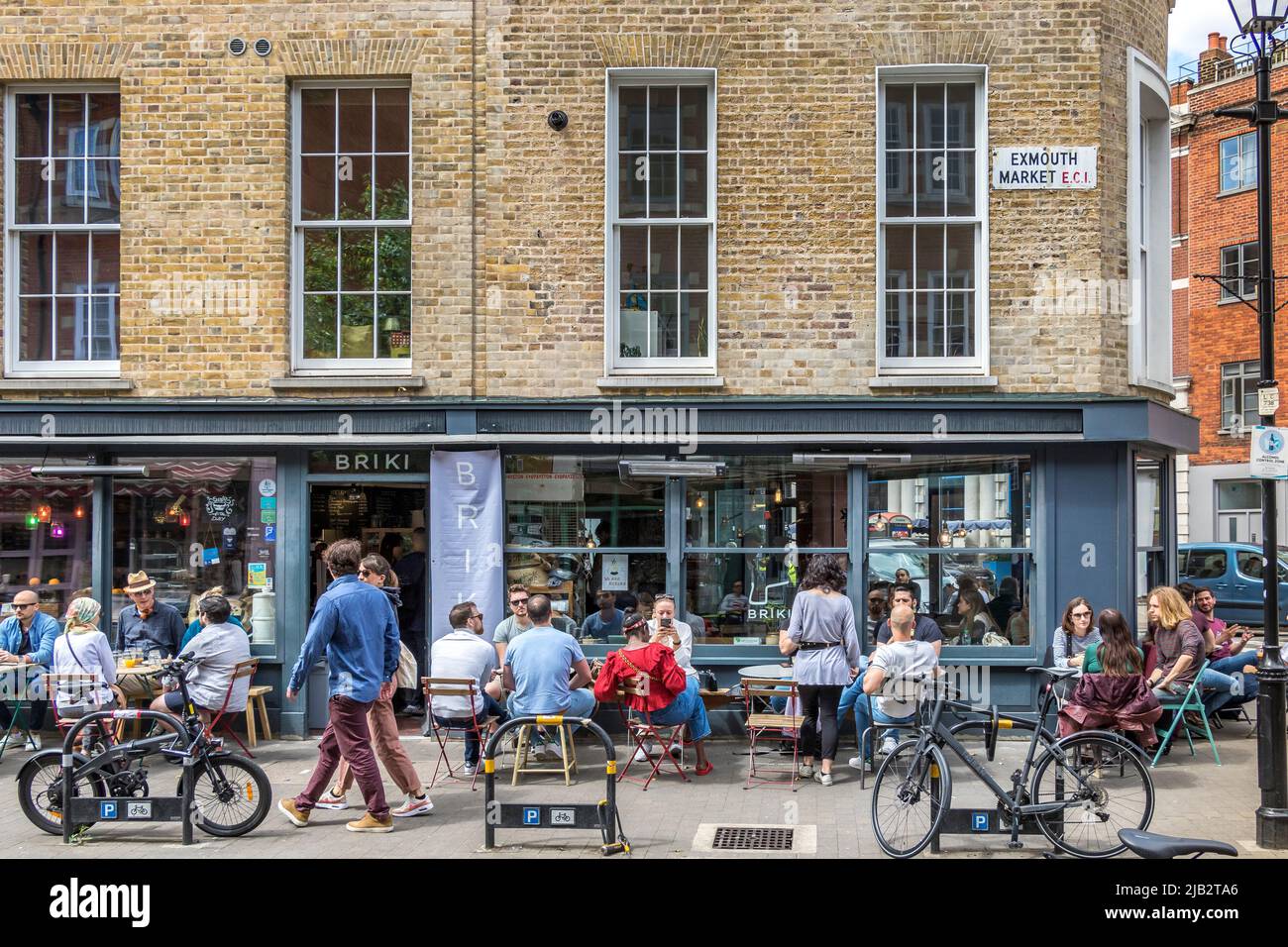People sitting outside Briki ,a busy deli and coffee shop and coffee brewery on Exmouth Market, Clerkenwell ,London EC1 Stock Photo