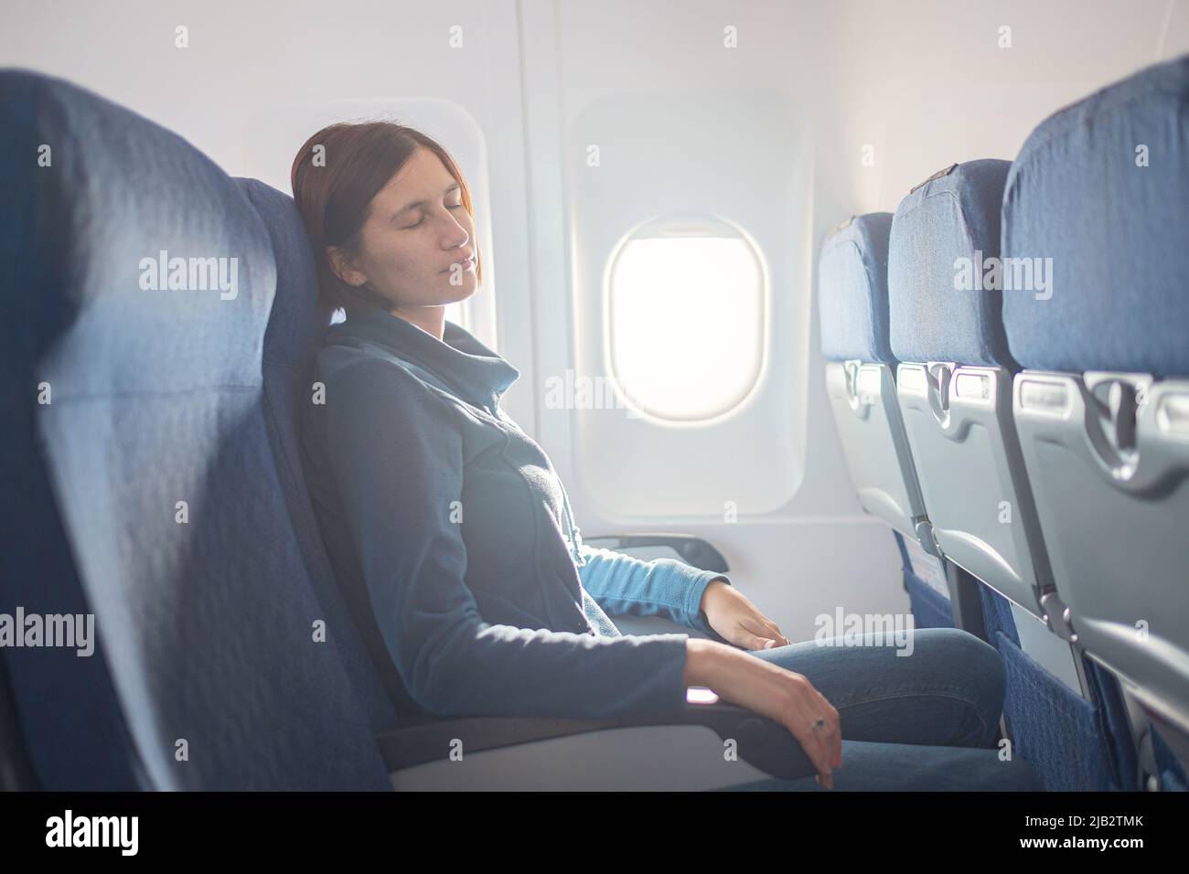 Fear of flying woman in plane sick with stress headache and motion