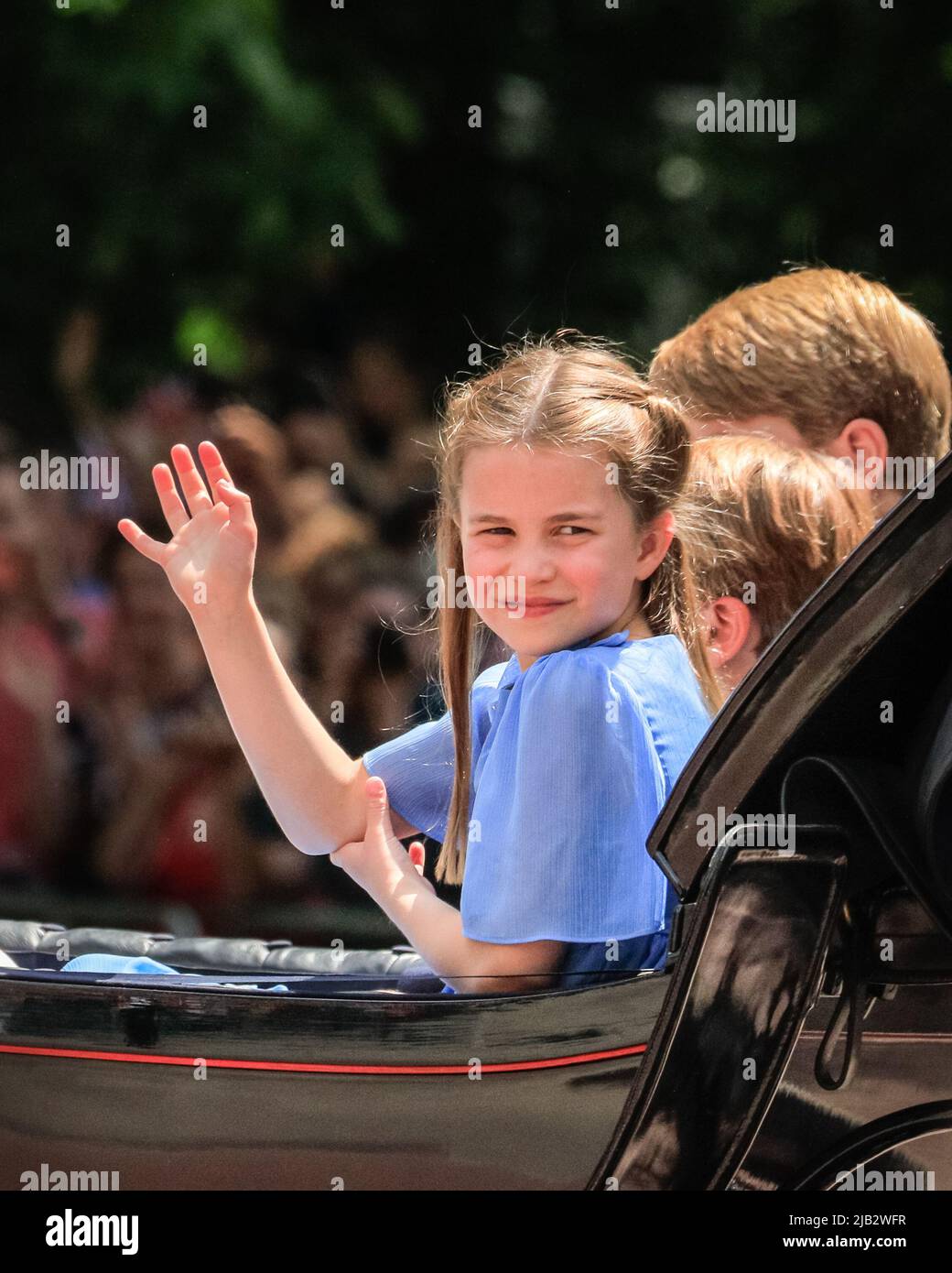 London, UK. 02nd June, 2022. Princess Charlotte waves from the carriage. Over 1,400 parading soldiers, 200 horses and 400 musicians from 10 bands in the traditional Parade mark The Queen's official birthday on the weekend which this year also sees her Platinum Jubilee. The Parade moves down The Mall to Horse Guard's Parade, joined by members of the Royal Family on horseback and in carriage and closes with the traditional RAF fly-past, watched by the Royal Family from the Buckingham Palace balcony. Stock Photo
