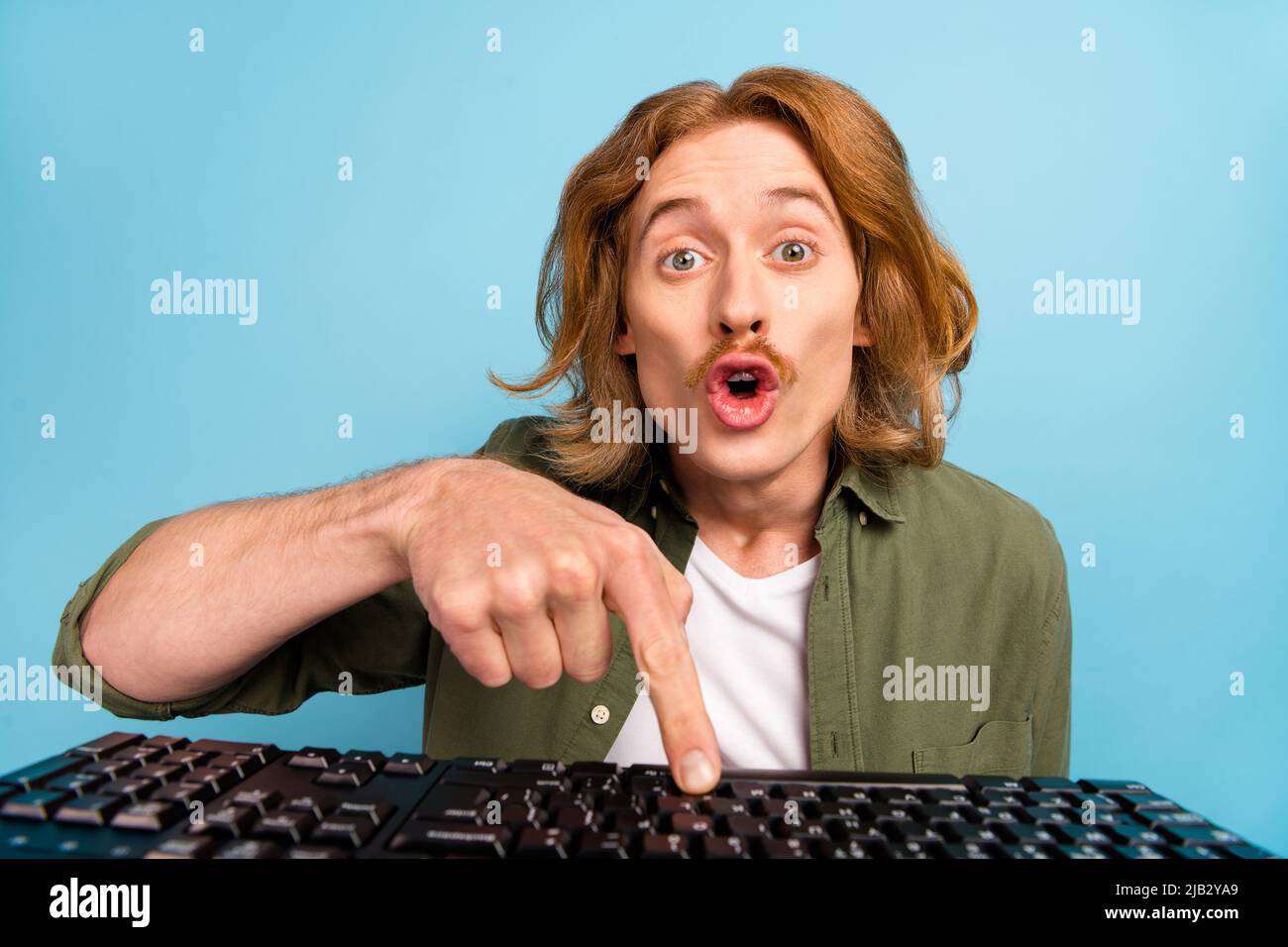Portrait of attractive funky stunned guy geek learder using computer ...