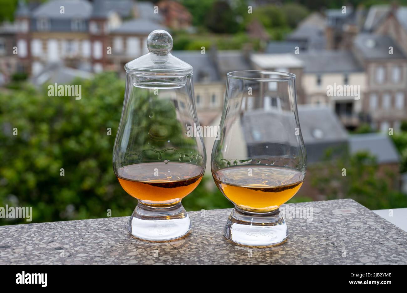 Two drams of scotch whiskey with view on old houses on background
